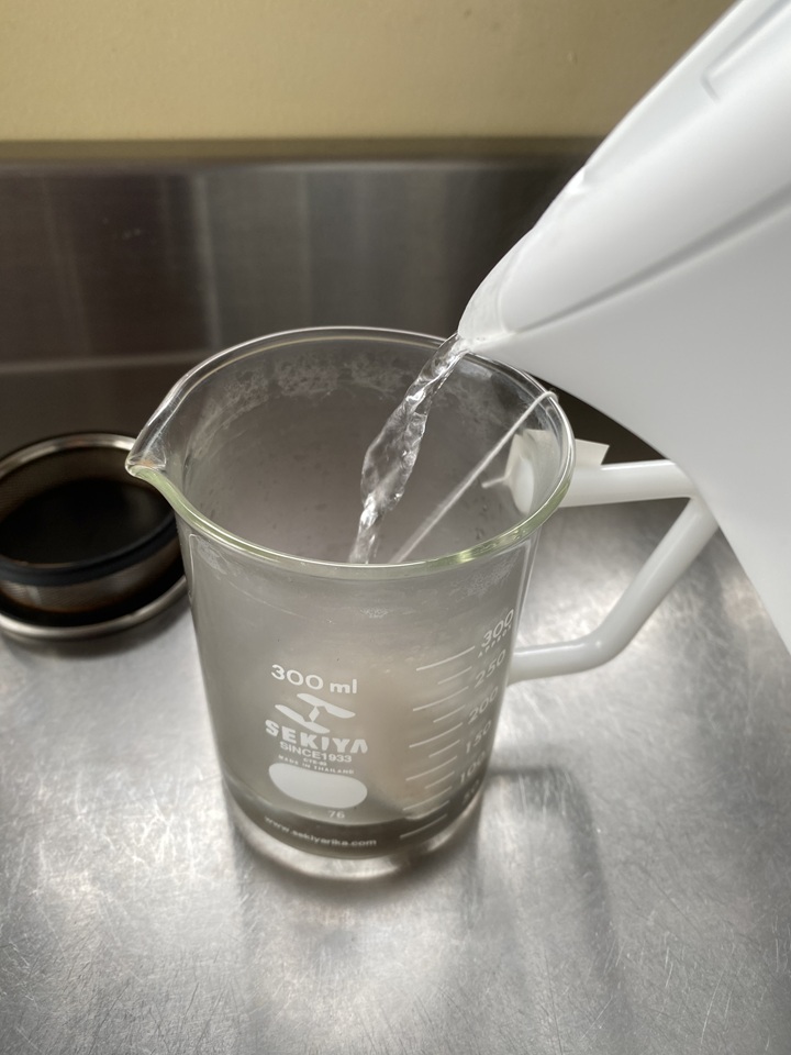 ビーカーにお湯を注ぐ